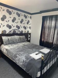 布莱克浦伍德菲尔德酒店的一间卧室配有一张带花卉壁纸的床
