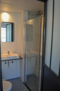 尼乌波特Hotel Sandeshoved Zeedijk的带淋浴、两个盥洗盆和卫生间的浴室