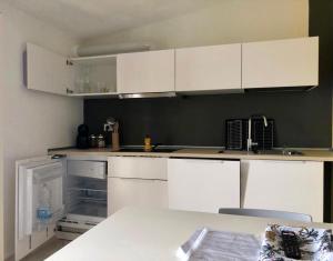 CampomarinoLuGa Apartments的厨房配有白色橱柜和白色台面