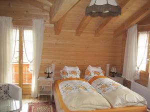 Sankt StephanGästehaus Alpenblick Wildstrubel的木墙和窗户的客房内的一张床位