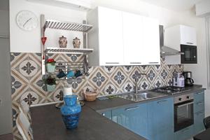 德瓦玛丽娜Villa Schiaffino Appartamento al Primo Piano的厨房配有蓝色橱柜和位于柜台上的蓝色花瓶