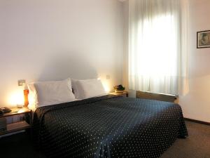 帕多瓦阿尔卡松酒店的卧室配有一张黑白床和窗户