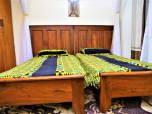 恩德培Lake Victoria Country Home的一间卧室配有一张带黄色和蓝色棉被的木床