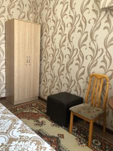 阿拉木图Hostel Viator的一间卧室配有椅子、一个行李箱和一个橱柜