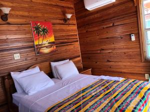 库尔克岛Blue Wave Guest House的卧室配有木墙内的一张床