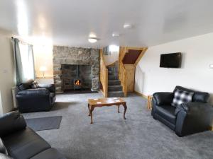 阿贝达隆Ty Rhos, Farm Stay, sleeps 4, Rhoshirwaun 2 miles from Aberdaron的带沙发和石制壁炉的客厅