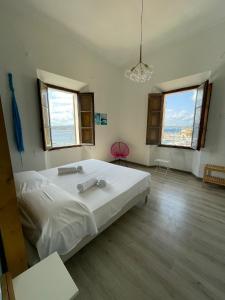 马达莱纳La Siesta的卧室设有一张白色大床和两个窗户。