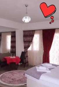 法马古斯塔Malia Holiday Let的卧室配有一张床,窗户上是红色的心