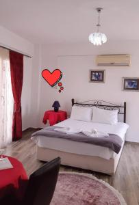 法马古斯塔Malia Holiday Let的卧室配有一张床,墙上有红色的心