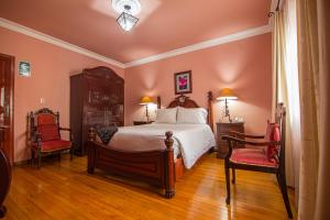 阿雷基帕阿雷基帕旅馆的一间卧室配有一张大床和两把椅子