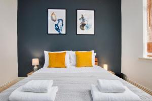 盖茨黑德Stylish 2 Bedroom Flat - Close To Newcastle City Centre的一间卧室配有一张带橙色枕头的大床