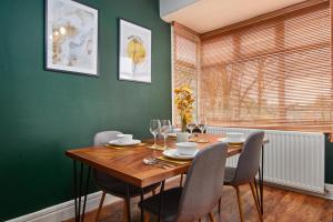 盖茨黑德Stylish 2 Bedroom Flat - Close To Newcastle City Centre的一间带木桌和椅子的用餐室