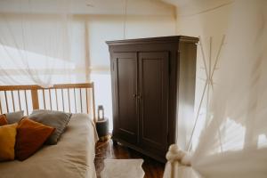 塔尔西Dunduriņi的一间卧室配有一张床和一个木制橱柜
