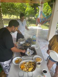 AntónCabaña Kundalini的一群男人站在桌子旁吃着食物