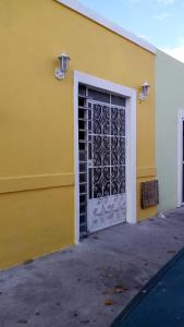 梅里达Casa Colonial Centro的黄色的建筑,上面有金属门