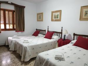 奥萨德蒙铁尔Casa Rural Sole的一间卧室配有两张红色和白色床单