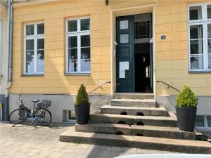 什未林Das Ferienapartment Alexandrine direkt am Pfaffenteich mit eigenem Parkplatz的一座建筑,前有黑色的门和一辆自行车