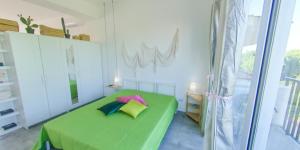 马尔扎梅米Fior di Sicilia Loft的一间卧室设有一张绿色的床和一个窗户。