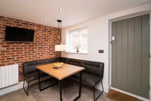 德比Modern finish to a historic brewers house, Derby的一间设有桌椅和砖墙的用餐室