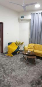 乌姆盖万شقة السلمة أم القيوين的客厅配有黄色的沙发和桌子