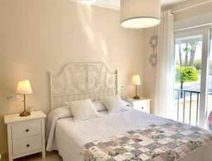 厄尔-汝姆披多Casa El Faro的一间卧室配有一张带白色床罩的床和窗户。