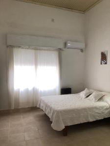 康考迪亚Acogedor departamento bien ubicado的卧室配有白色的床和窗户。