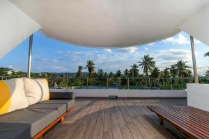 拉斯特拉纳斯Puerto Plaza Las Terrenas的带沙发的客厅和带棕榈树的阳台。