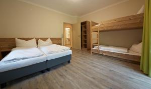 萨尔巴赫Holiday Lodge Central的一间卧室设有两张双层床,铺有木地板。