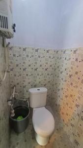 沃诺索博DIENG GHUZY HOUSE syariah family room的一间带卫生间和桶的浴室