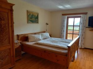 圣沃尔夫冈保罗鲍尔酒店的一间卧室设有一张木床和一个窗户。