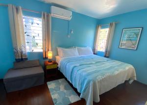 蒙特哥贝The Blue Orchid B&B的蓝色卧室,配有床和椅子