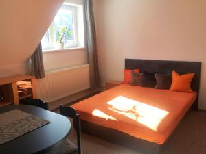 贝德日霍夫Ubytování Kuncovi的一间卧室配有带橙色床单的床和窗户。