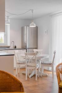 卡雷扎湖Renoviertes Apartment mit Terrasse an der Piste mit kostenlosen WiFi的白色的厨房配有白色的桌子和椅子