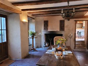帕尔特奈La Cressonnière的客厅配有桌子和壁炉