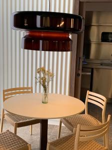 普奇塞达CIM HOTEL BOUTIQUE的一张桌子和椅子,上面有花瓶