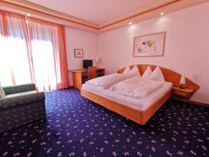 拉纳Hotel Burgleitenhof的一间卧室配有一张床、一张桌子和一张沙发