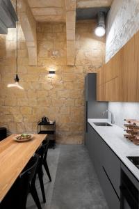 科斯皮夸NUMRU 27 Expertly restored small house of character的厨房配有木桌和石墙