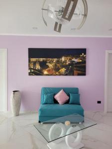 卡梅罗塔码头Mare Azzurro的客厅配有蓝色沙发和绘画作品