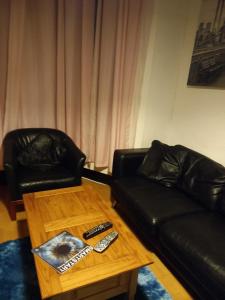 查塔姆Alistair lodge的客厅配有真皮沙发和茶几