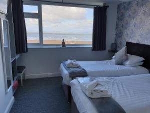 莫克姆Balmoral的酒店客房,设有两张床,享有海滩景色
