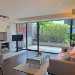 墨尔本Light-filled apartment in a dream location 150m away from University of Melbourne的客厅配有沙发和桌子