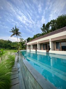 日惹boutique villa jogja senang的棕榈树建筑前的游泳池