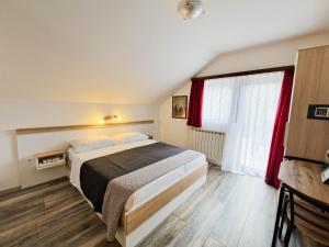 斯莫利亚纳茨鲁扎旅馆的一间卧室配有床和红色窗帘的窗户