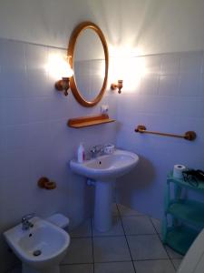 圣特雷莎加卢拉Casa GiovanMarco con vista mare的一间带水槽、镜子和卫生间的浴室