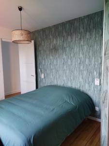 BalleroyGite le Biardais的一间卧室设有一张绿色的床和一面墙
