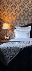 布鲁日布里格诗套房- 豪华酒店的一张带枕头的床和一张桌子上的台灯