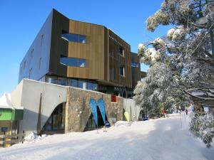 布勒山布勒中央酒店 的雪中拥有蓝色滑雪板的建筑