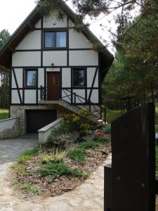 DziemianyRaduńska Ostoja的白色和黑色的房子,有院子