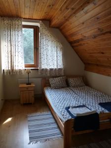 DziemianyRaduńska Ostoja的一间小卧室,阁楼上配有一张床