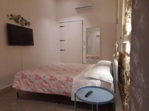 锡拉库扎Casa Maria的一间卧室配有一张床、一张桌子和一台电视。